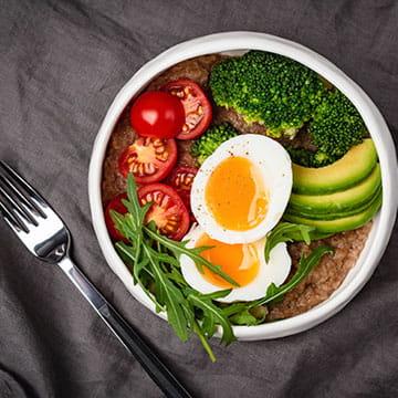 均衡膳食碗鸡蛋，鳄梨，花椰菜，和西红柿 